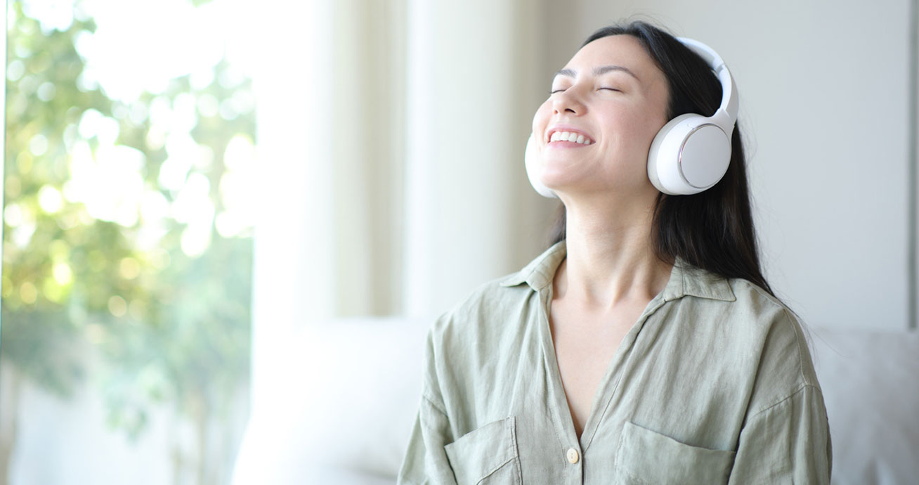 woman-wearing-headphones-and-smiling-with-eyes-closed